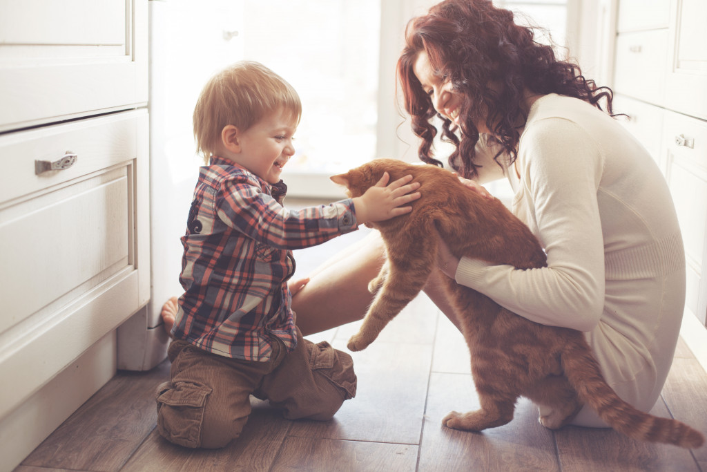 mother with baby playing with cat