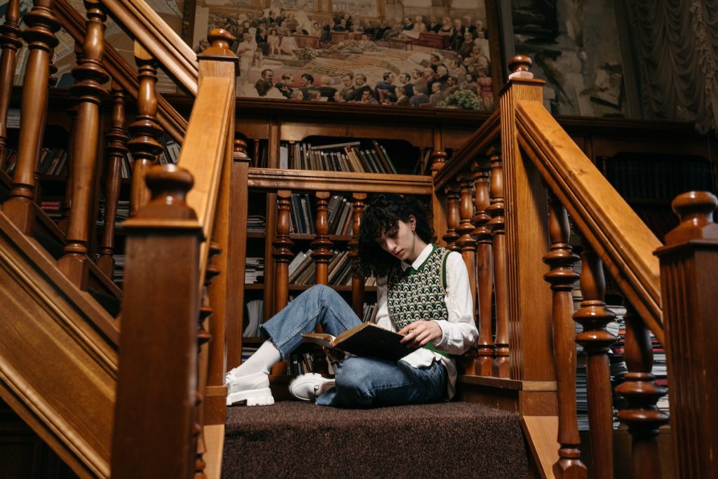 a woman reading a book inside a library